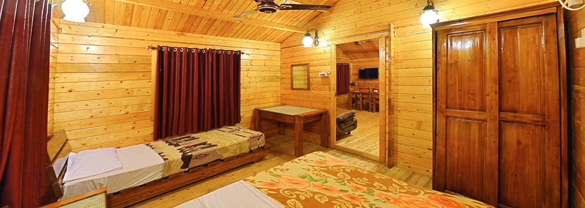 Wooden cottage with beds, table, adjoining room with dining arrangement in Bluebay Beach Resort, ECR, Chennai