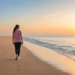 Woman enjoying a peaceful sunrise walk along the beach near Chennai